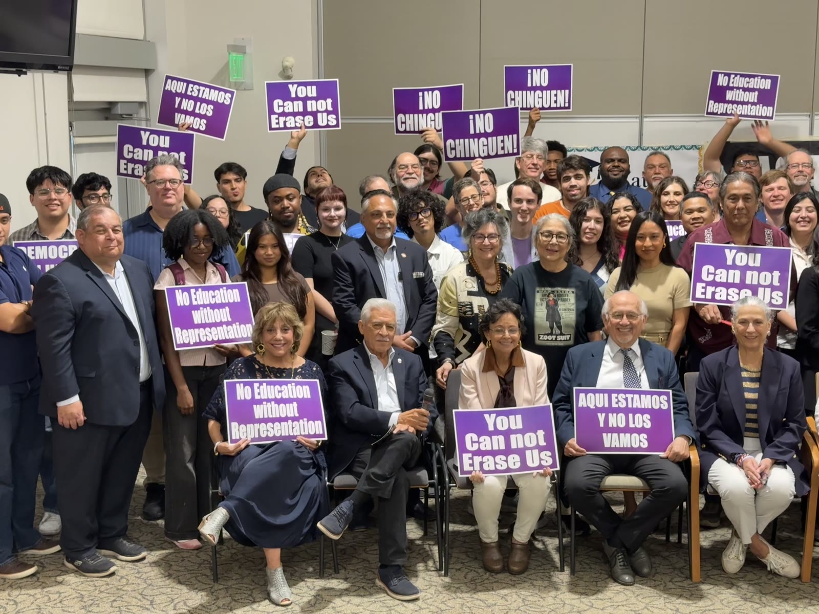 People’s Hearing participants gathered with signs supporting representation in higher education